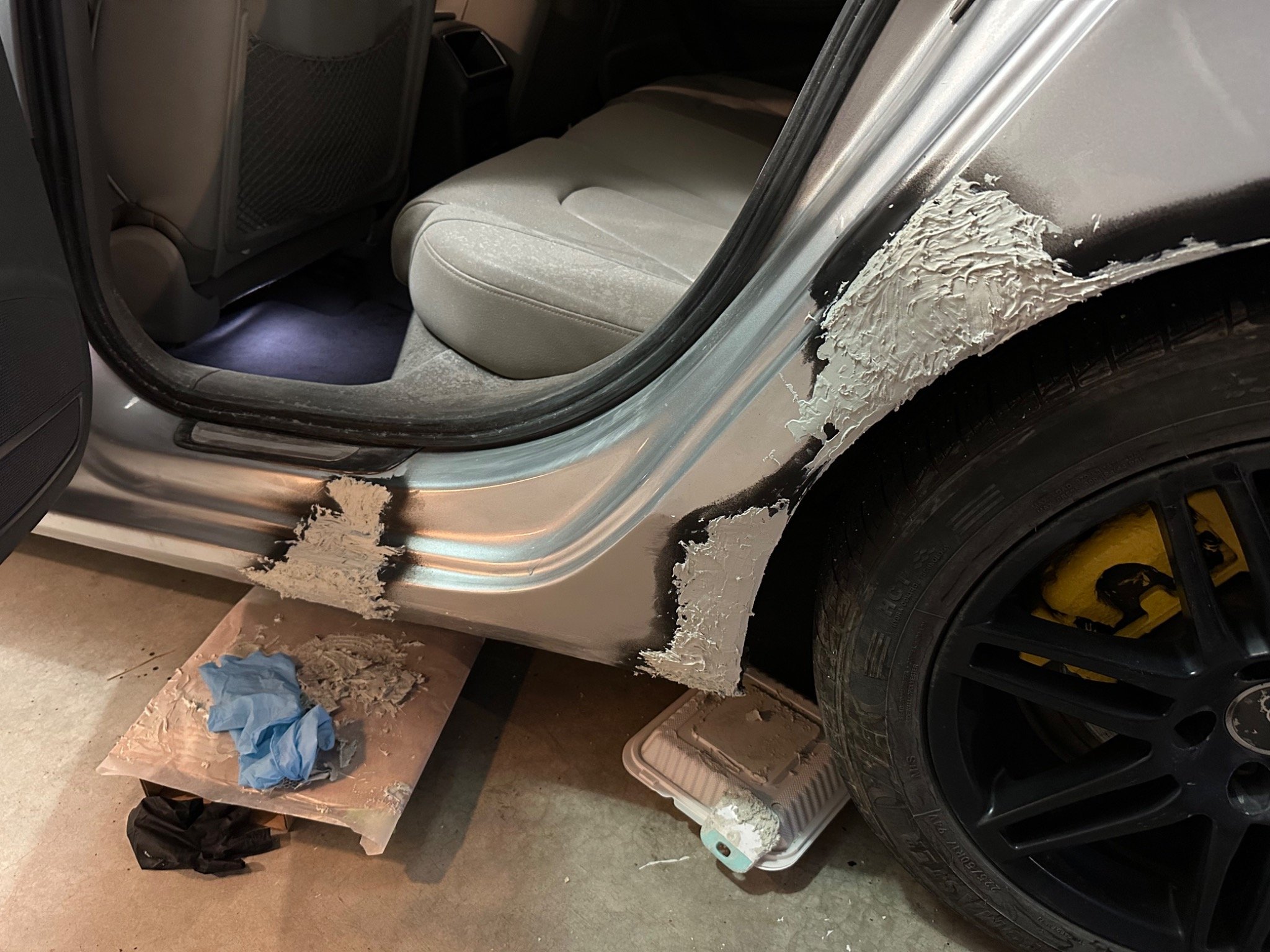 Body filler applied around the wheel arch and door opening
