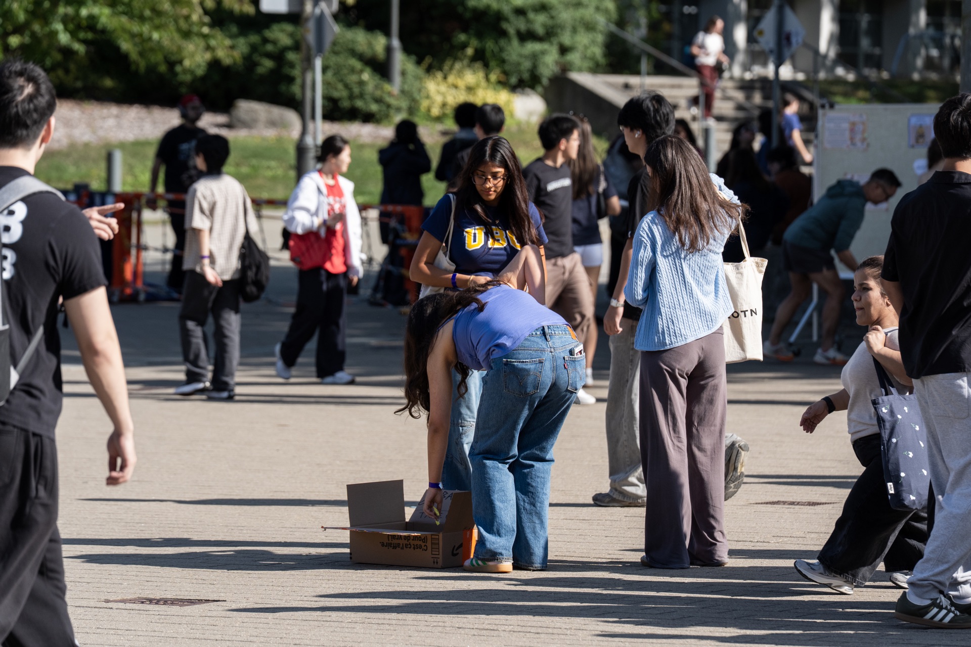 A participant reaches into the box while others watch