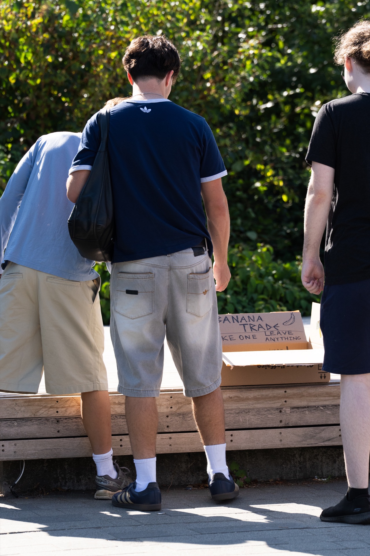People stop to look into the banana box on the wooden platform