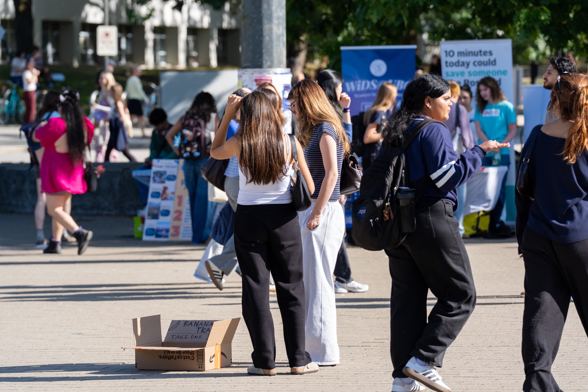 People pause beside the box as others walk past
